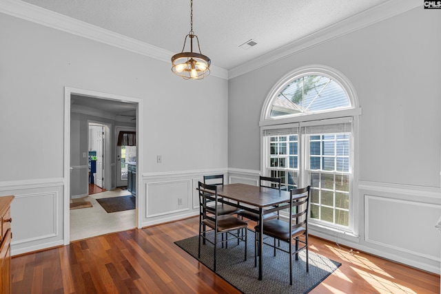 108 Sawgrass Ct, West Columbia, SC 29172 - dining space featuring crown molding, wood finished floors, a decorative wall, a wainscoted wall, and a textured ceiling