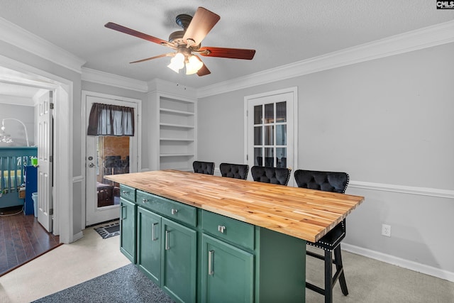 108 Sawgrass Ct, West Columbia, SC 29172 - kitchen with green cabinetry, butcher block countertops, a ceiling fan, crown molding, and a breakfast bar area