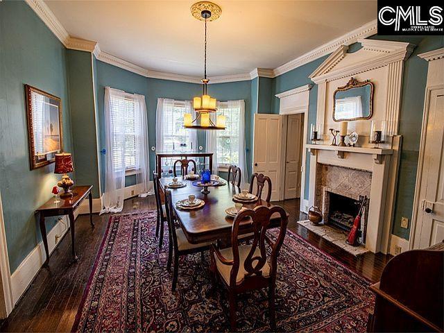 1220 Calhoun St, Newberry, SC 29108 - dining room featuring wood-type flooring, a fireplace, and ornamental molding