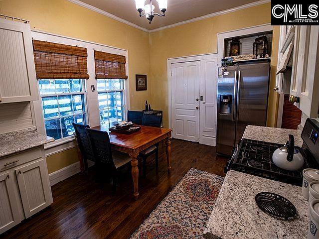 1220 Calhoun St, Newberry, SC 29108 - dining room featuring crown molding, dark wood finished floors, and a chandelier