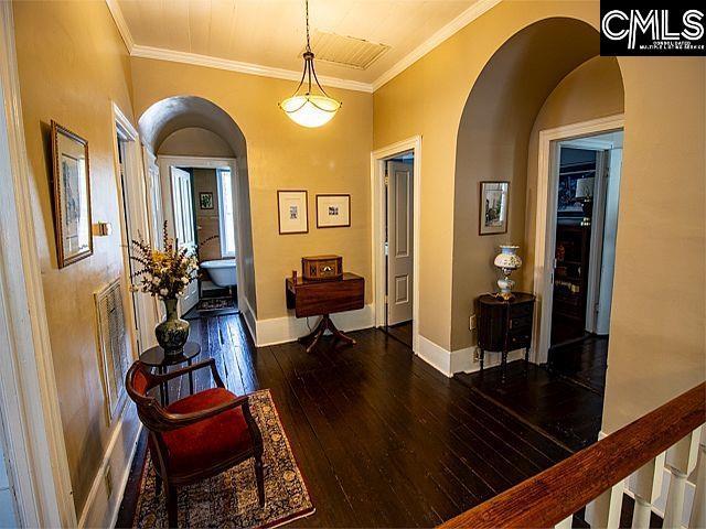 1220 Calhoun St, Newberry, SC 29108 - entrance foyer featuring arched walkways, dark wood-type flooring, and ornamental molding