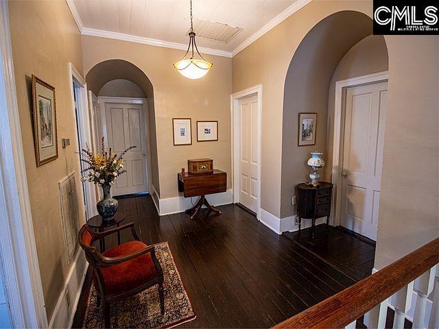1220 Calhoun St, Newberry, SC 29108 - entrance foyer with arched walkways, dark wood-type flooring, and crown molding