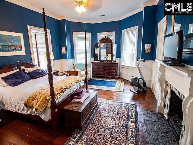 1220 Calhoun St, Newberry, SC 29108 - bedroom with hardwood / wood-style floors, ornamental molding, and a fireplace