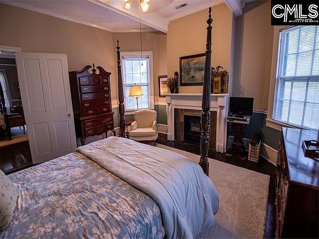 1220 Calhoun St, Newberry, SC 29108 - bedroom featuring crown molding, a fireplace, and wood finished floors