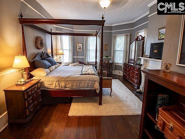 1220 Calhoun St, Newberry, SC 29108 - bedroom with wood-type flooring and crown molding