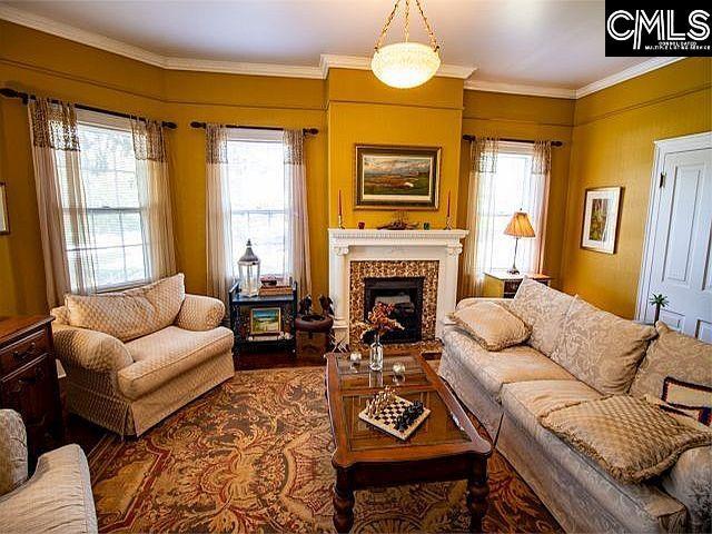 1220 Calhoun St, Newberry, SC 29108 - living room featuring a fireplace, wood finished floors, and crown molding