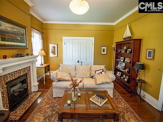 1220 Calhoun St, Newberry, SC 29108 - living room with wood finished floors, crown molding, and a high end fireplace