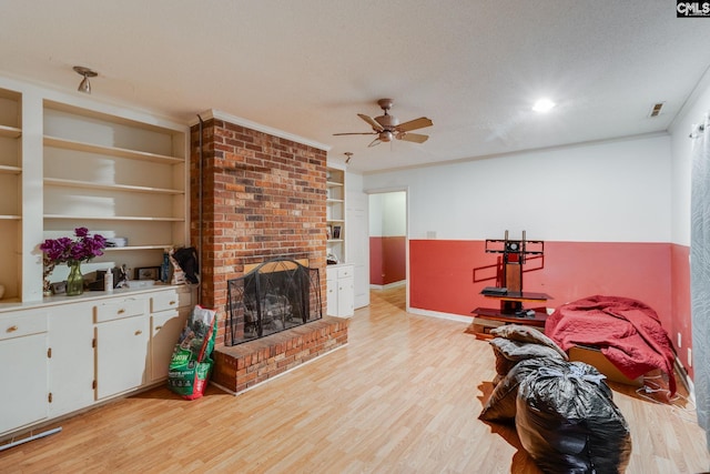 2161 Tanglewood Rd, Sumter, SC 29154 - living area with light wood-style flooring, a ceiling fan, a fireplace, built in shelves, and crown molding