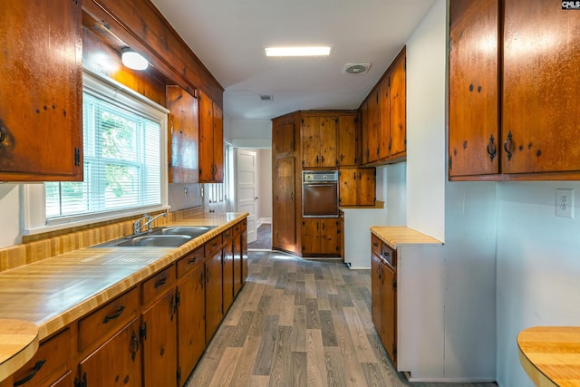 318 Summerland Ave, Batesburg, SC 29006 - kitchen with wall oven, wood finished floors, light countertops, and brown cabinets