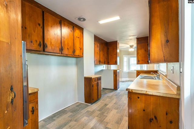 318 Summerland Ave, Batesburg, SC 29006 - kitchen featuring brown cabinets, light wood finished floors, light countertops, and ceiling fan