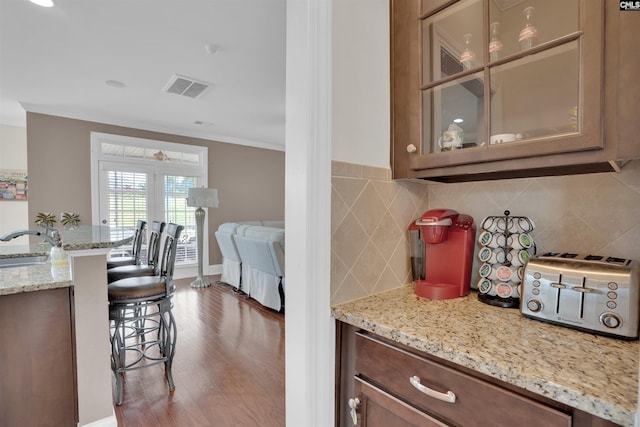 769 Broad Leaf Rd, Elgin, SC 29045 - kitchen with a breakfast bar, glass insert cabinets, tasteful backsplash, wood finished floors, and crown molding