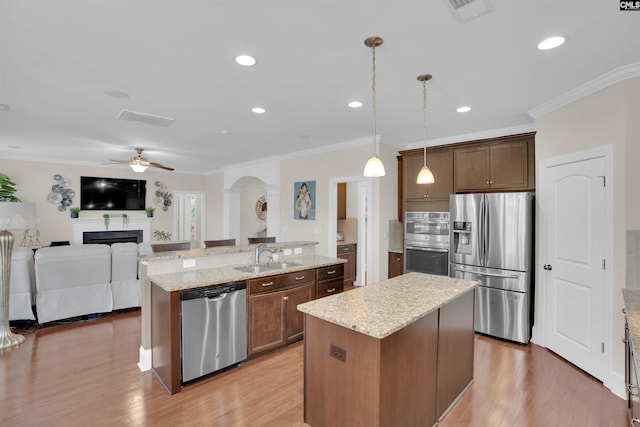 769 Broad Leaf Rd, Elgin, SC 29045 - kitchen with appliances with stainless steel finishes, an island with sink, ceiling fan, ornamental molding, and light wood-style floors