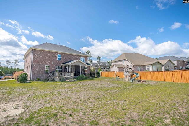 769 Broad Leaf Rd, Elgin, SC 29045 - rear view of property with a sunroom, a playground, brick siding, a fenced backyard, and a residential view