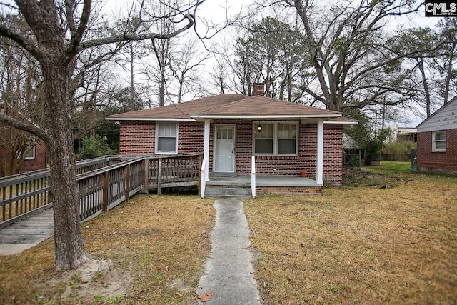 113 Brookland Cir, Columbia, SC 29204 - bungalow-style house featuring a chimney, brick siding, roof with shingles, a front yard, and a porch