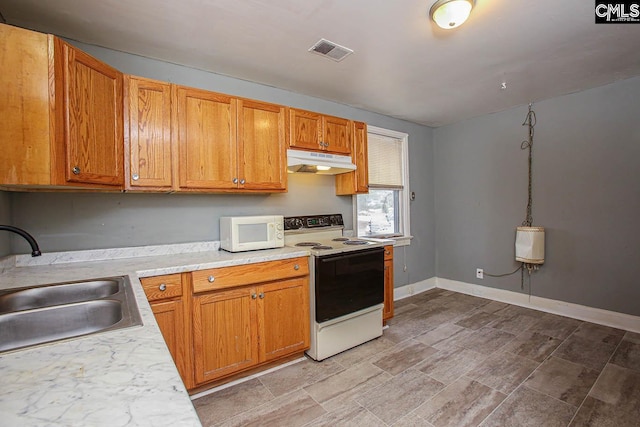 113 Brookland Cir, Columbia, SC 29204 - kitchen with white appliances, under cabinet range hood, light countertops, and brown cabinets