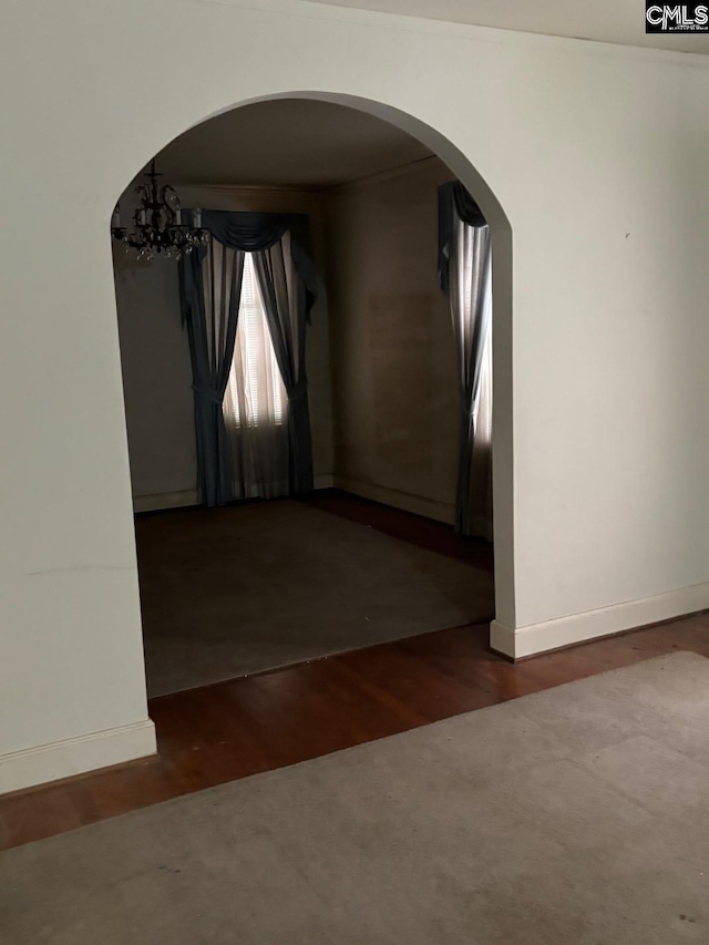 209 E Columbia Ave, Batesburg, SC 29070 - unfurnished room with arched walkways, wood finished floors, and a chandelier