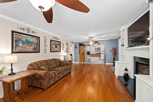 1220 Barnwell Dr, Sumter, SC 29154 - living area with a ceiling fan, crown molding, light wood-style flooring, a fireplace, and a textured ceiling