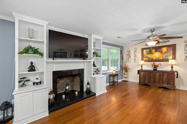 1220 Barnwell Dr, Sumter, SC 29154 - living room featuring a textured ceiling, wood finished floors, a ceiling fan, crown molding, and a fireplace with raised hearth