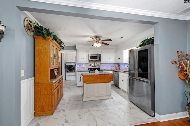 1220 Barnwell Dr, Sumter, SC 29154 - kitchen with stainless steel appliances, washer / dryer, ceiling fan, a kitchen island, and white cabinets
