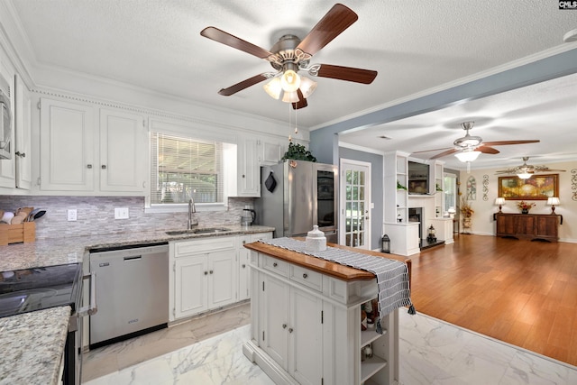 1220 Barnwell Dr, Sumter, SC 29154 - kitchen featuring appliances with stainless steel finishes, a ceiling fan, light marble finish flooring, open floor plan, and white cabinetry