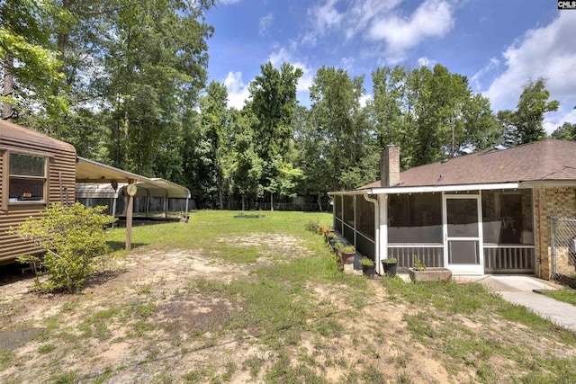 1220 Barnwell Dr, Sumter, SC 29154 - view of grassy yard featuring a sunroom and a detached carport