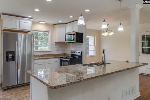 1748 Omarest Dr, Columbia, SC 29210 - kitchen with appliances with stainless steel finishes, crown molding, white cabinetry, light wood-style flooring, and light stone counters
