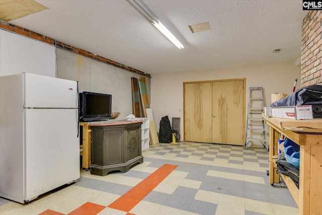 518 Pioneer Shores Rd, Prosperity, SC 29127 - basement featuring freestanding refrigerator, light flooring, a textured ceiling, and a wood stove