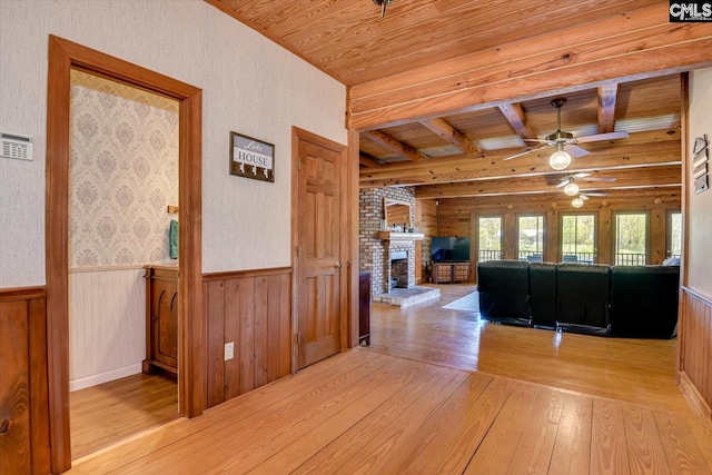 518 Pioneer Shores Rd, Prosperity, SC 29127 - living room with light wood finished floors, a wood ceiling with exposed beams, ceiling fan, a wainscoted wall, and a fireplace