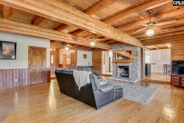 518 Pioneer Shores Rd, Prosperity, SC 29127 - living room featuring ceiling fan, a brick fireplace, light wood-style flooring, a wooden ceiling with exposed beams, and wainscoting
