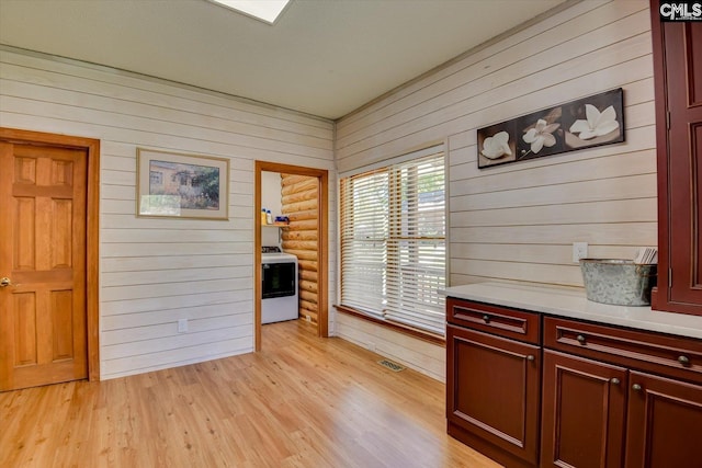 518 Pioneer Shores Rd, Prosperity, SC 29127 - interior space with light countertops, range, light wood-style flooring, dark brown cabinets, and wooden walls