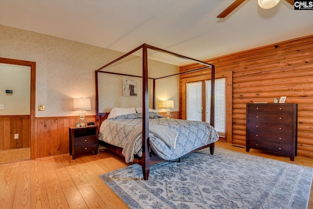 518 Pioneer Shores Rd, Prosperity, SC 29127 - bedroom with wainscoting, wood finished floors, rustic walls, and a ceiling fan