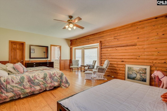 518 Pioneer Shores Rd, Prosperity, SC 29127 - bedroom featuring wainscoting, log walls, wood finished floors, a textured ceiling, and a ceiling fan