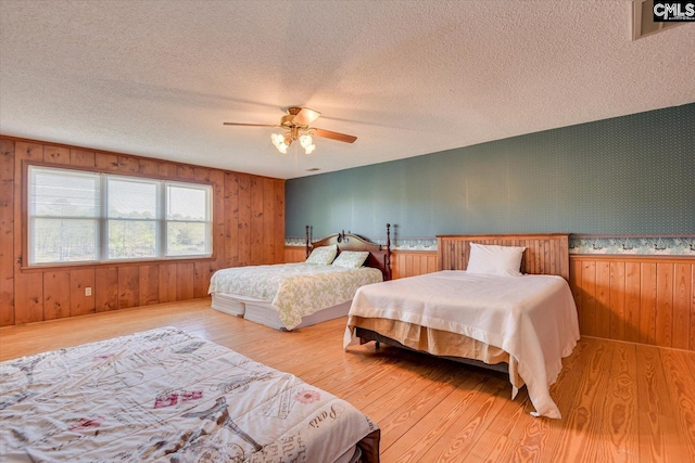 518 Pioneer Shores Rd, Prosperity, SC 29127 - bedroom featuring light wood-style floors, a textured ceiling, wooden walls, and a ceiling fan