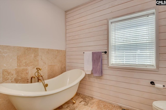 518 Pioneer Shores Rd, Prosperity, SC 29127 - bathroom featuring wood walls, a freestanding bath, and tile walls