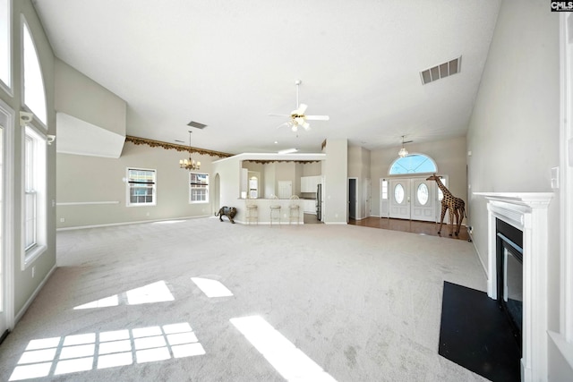 216 Founders Ridge Rd, Columbia, SC 29229 - unfurnished living room with carpet flooring, a fireplace with flush hearth, a ceiling fan, a chandelier, and a towering ceiling