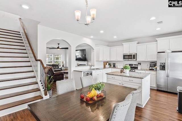 823 Queenshire Ln, Elgin, SC 29045 - dining room featuring stairway, a chandelier, recessed lighting, ceiling fan, and arched walkways