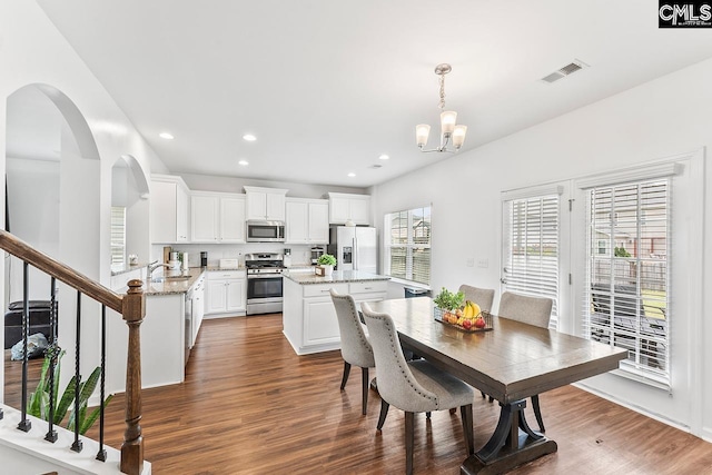 823 Queenshire Ln, Elgin, SC 29045 - dining space with dark wood-style flooring, a chandelier, recessed lighting, arched walkways, and stairs
