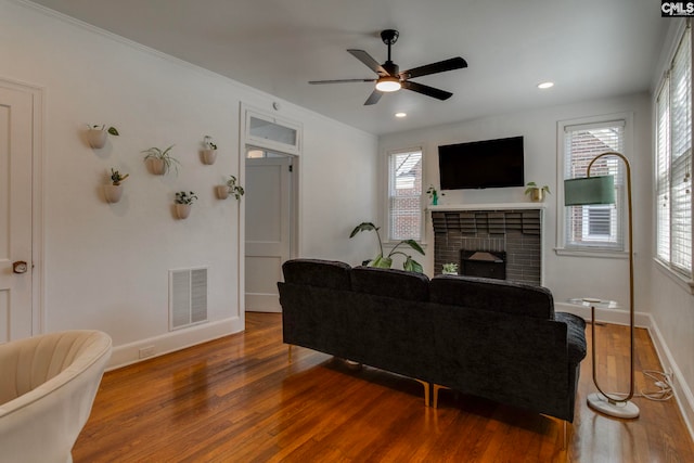 335-337 S Woodrow St, Columbia, SC 29205 - living room featuring wood finished floors, a brick fireplace, a ceiling fan, recessed lighting, and crown molding