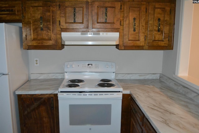 169 Lionsgate Rd, Columbia, SC 29223 - kitchen with under cabinet range hood, white appliances, light countertops, and brown cabinetry