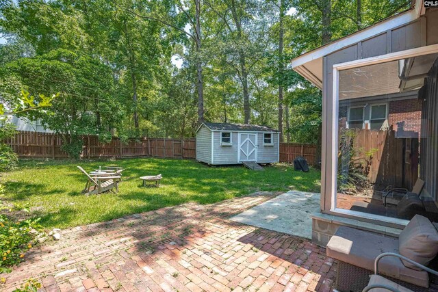 711 Sunset Dr, Columbia, SC 29203 - fenced backyard featuring a fire pit, a patio area, a storage unit, and view of scattered trees