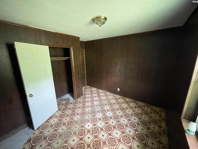 110 Quattlebaum Ave, Ridge Spring, SC 29129 - unfurnished bedroom with wood walls, a closet, and a textured ceiling