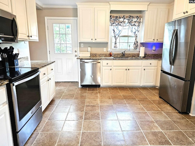 904 Sunnyhill Dr, Camden, SC 29020 - kitchen with appliances with stainless steel finishes, ornamental molding, dark stone countertops, stone finish flooring, and white cabinets