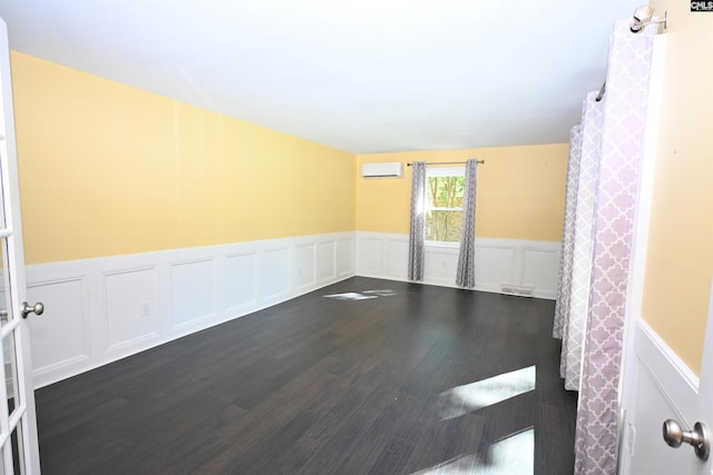 214 Mac St, Leesville, SC 29070 - unfurnished room with a wall mounted AC, a wainscoted wall, dark wood-style floors, and a decorative wall
