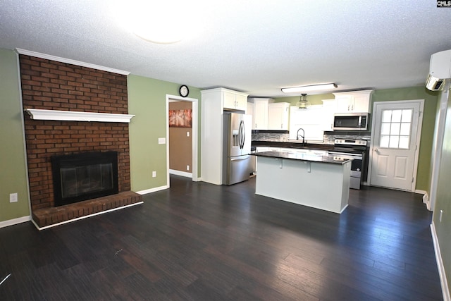 214 Mac St, Leesville, SC 29070 - kitchen featuring appliances with stainless steel finishes, dark countertops, white cabinetry, an AC wall unit, and a textured ceiling