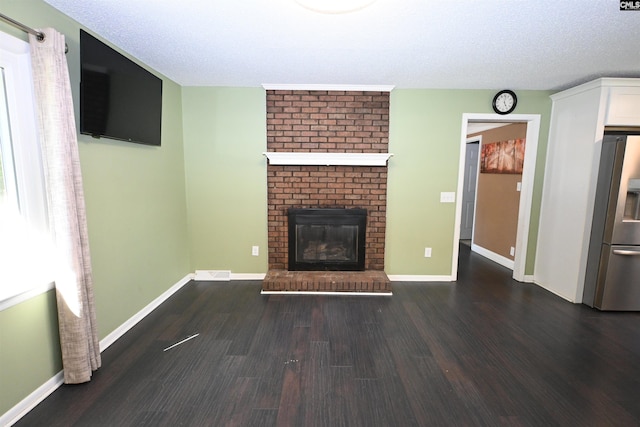 214 Mac St, Leesville, SC 29070 - unfurnished living room with a brick fireplace, wood finished floors, and a textured ceiling