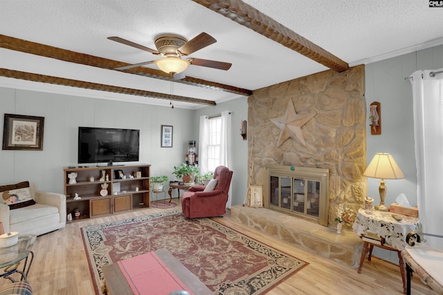 122 Partridge Hill Dr, West Columbia, SC 29172 - living area with a textured ceiling, wood finished floors, ceiling fan, beamed ceiling, and a stone fireplace