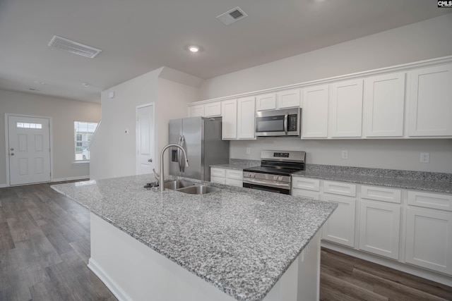 739 Wild Duck Ln, Columbia, SC 29203 - kitchen with appliances with stainless steel finishes, white cabinetry, a kitchen island with sink, dark wood finished floors, and light stone countertops
