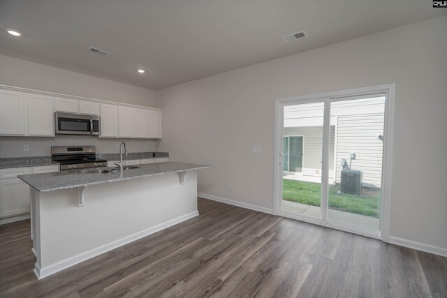 739 Wild Duck Ln, Columbia, SC 29203 - kitchen with appliances with stainless steel finishes, dark wood-style floors, a kitchen island with sink, white cabinets, and recessed lighting