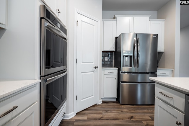 186 Backspin Dr, Elgin, SC 29045 - kitchen with stainless steel appliances, dark wood-style floors, white cabinetry, and light stone counters