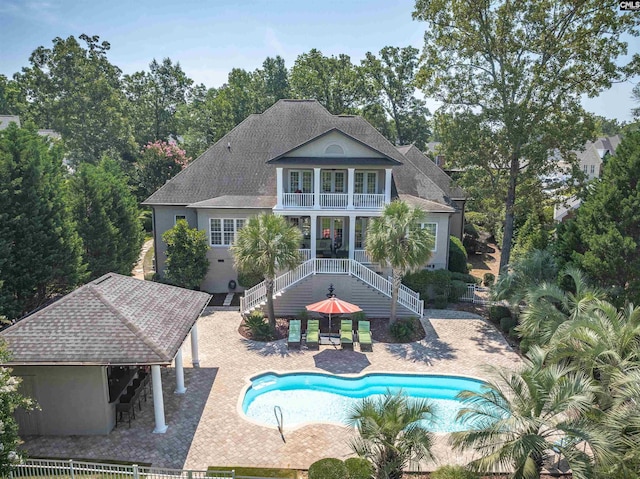 226 Forty Love Pt, Chapin, SC 29036 - rear view of house featuring a balcony, stairs, roof with shingles, a patio area, and an outdoor pool